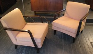 This Pair of Upholstered Lounge Chairs are attributed to Gilbert Rohde, and look to be early Herman Miller. The seat is low at 15", and the arms and legs are a dark, rich, Walnut. The seat pads have new foam, and the undersprings and back are nice and tight. The chairs have been redone once quite a while ago, and though they present well as they are, the faded salmon cotton could probably do well with a steam cleaning. Measure 30"d X 25"w X 28"h.