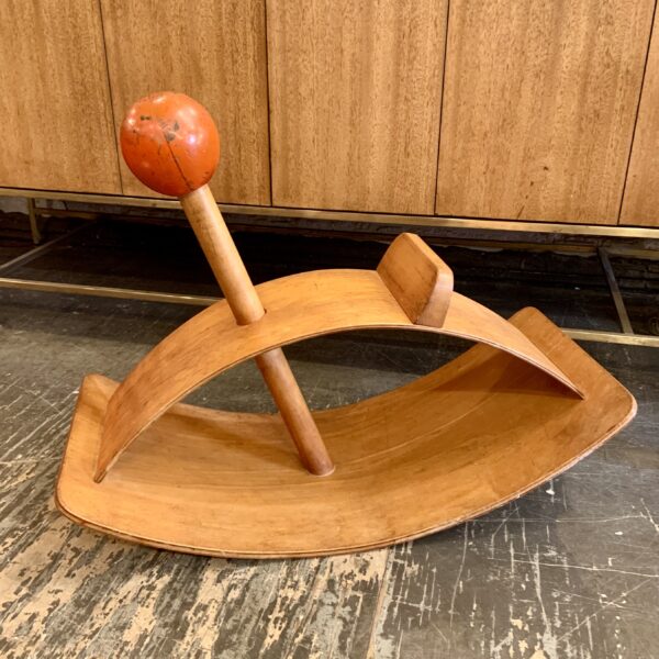 An abstract hobby horse designed in 1964 by Gloria Caranica for Creative Playthings. Composed of two arched panels of birch plywood divided by a solid birch shaft and topped with a charming red knob. Impressive as both a children's toy and modernist sculpture with its clean lines and graceful form. Excellent, original condition with